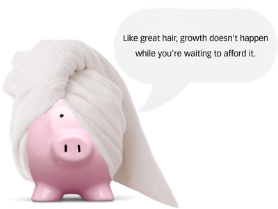 A pink piggy bank with a towel wrapped around its head and a speech bubble that says 'Like great hair, growth doesn't happen while you're waiting to afford it.'.